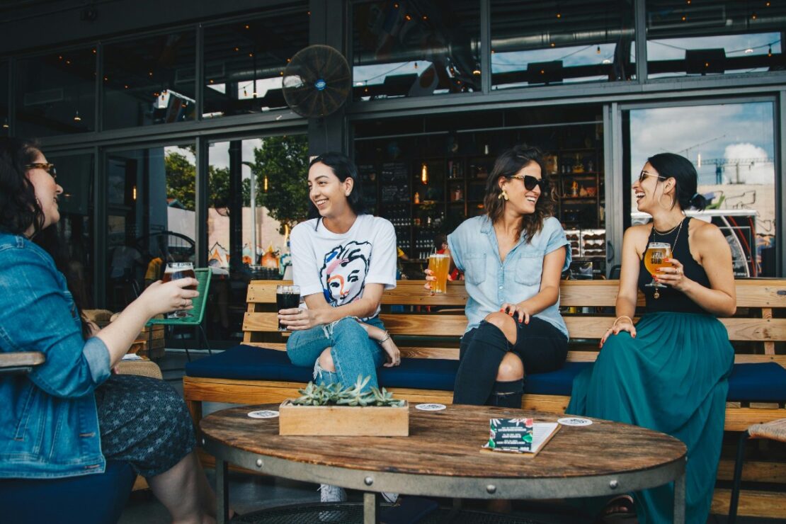 women sitting on benches laughing